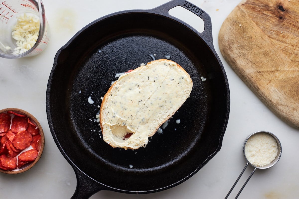 garlic buttered bread in cast iron skillet to make pizza grilled cheese. 