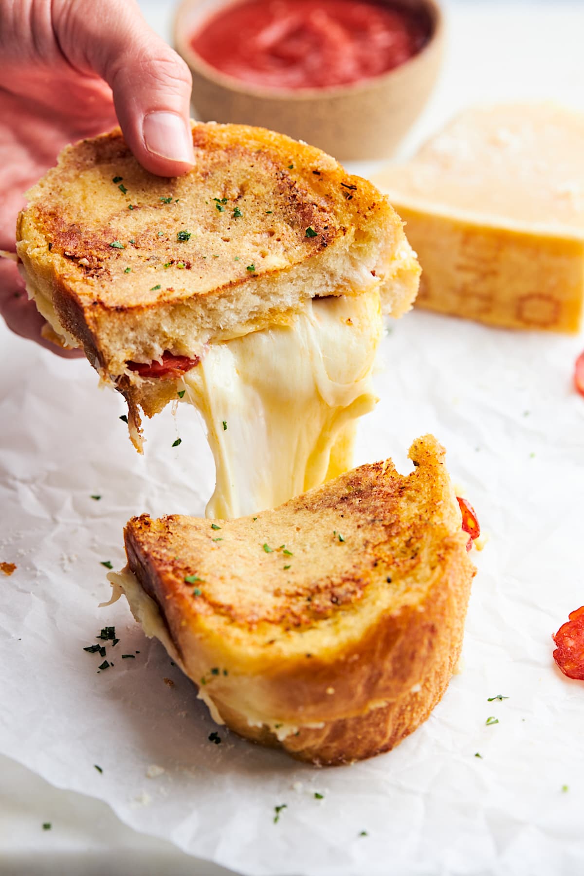 pizza grilled cheese cut in half with cheese pull. 