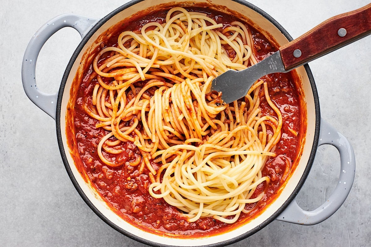 spaghetti with meat sauce in large pot with serving fork. 