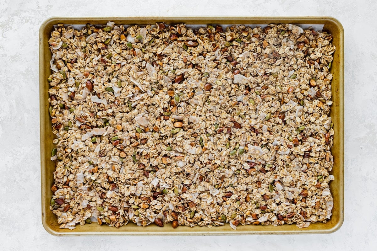 granola spread out on baking sheet before going in oven. 