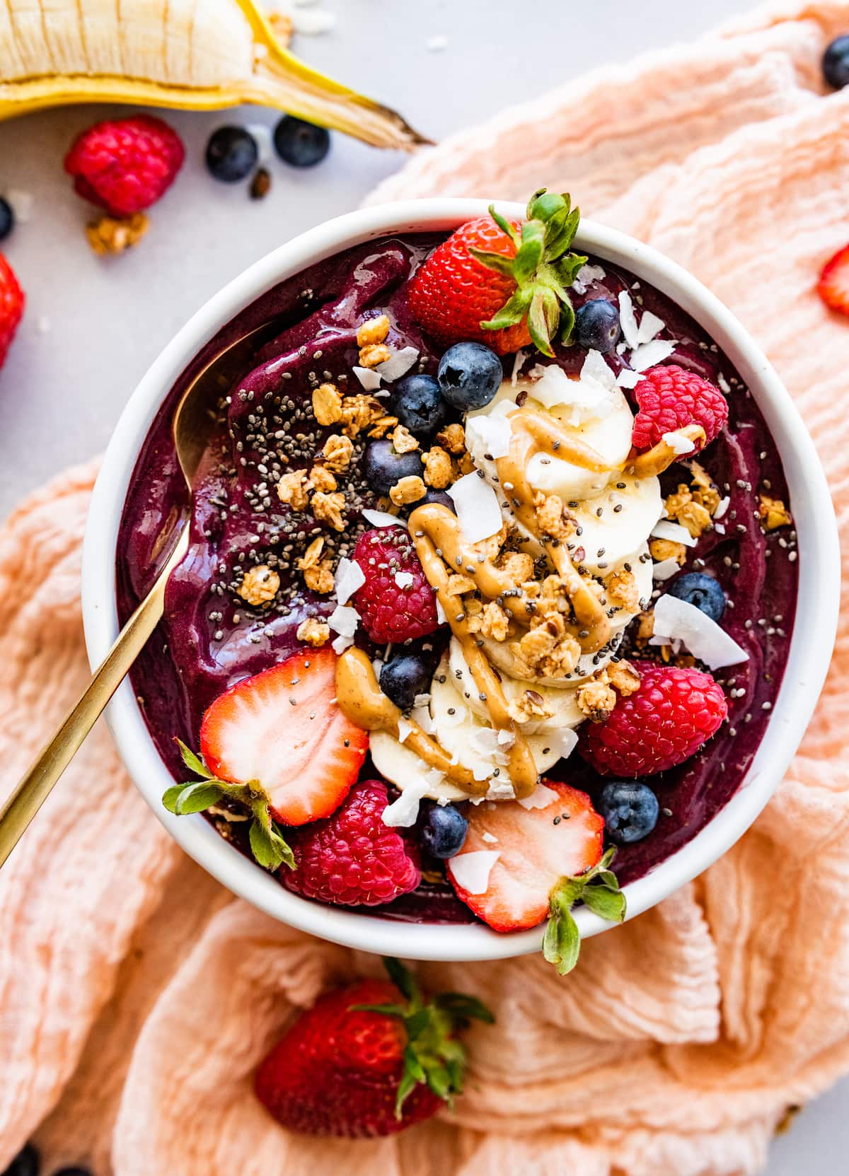 acai bowl with fresh fruit, chia seeds, coconut, and drizzle of peanut butter. 