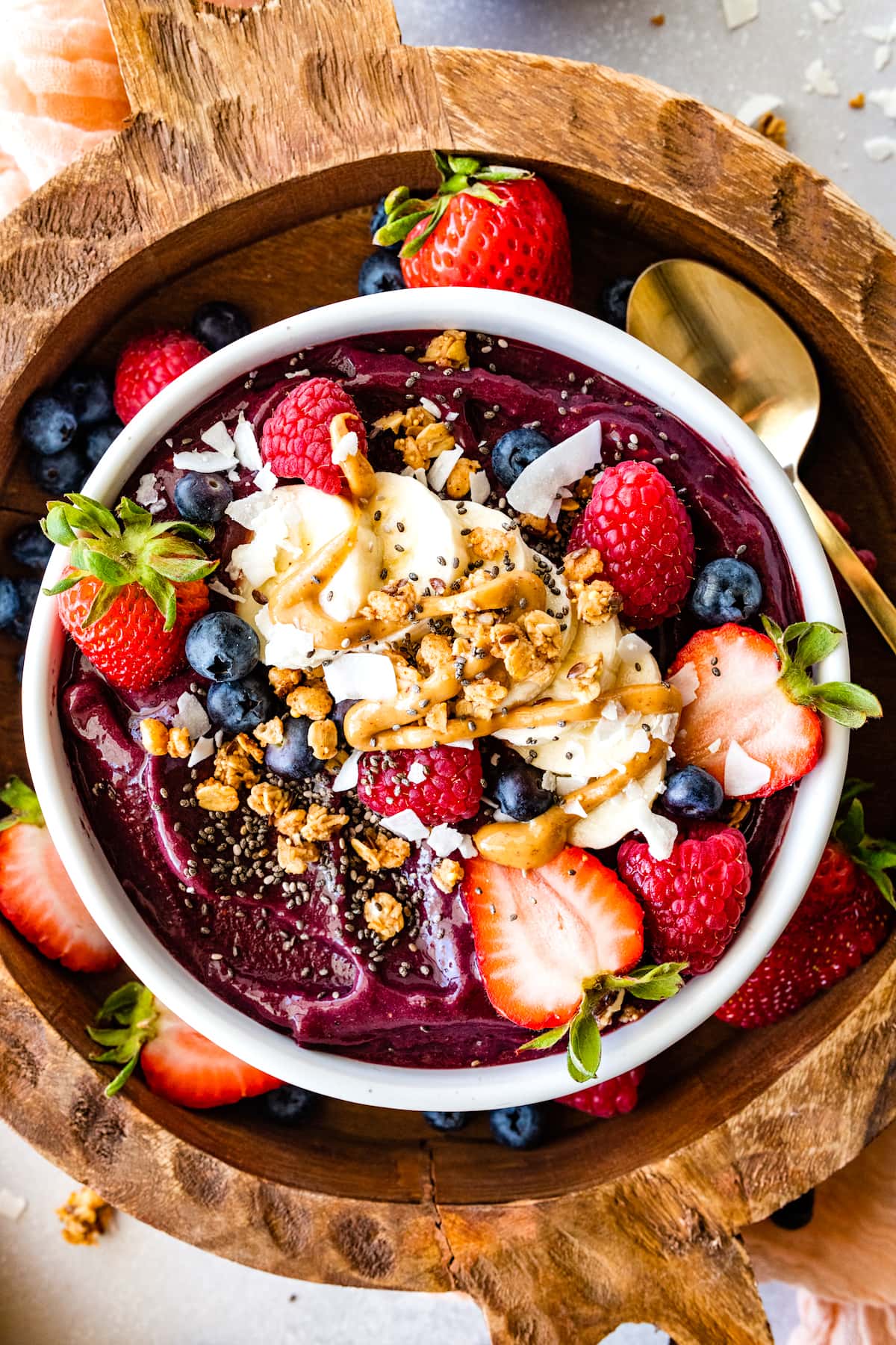 acai bowl with toppings on wood board.