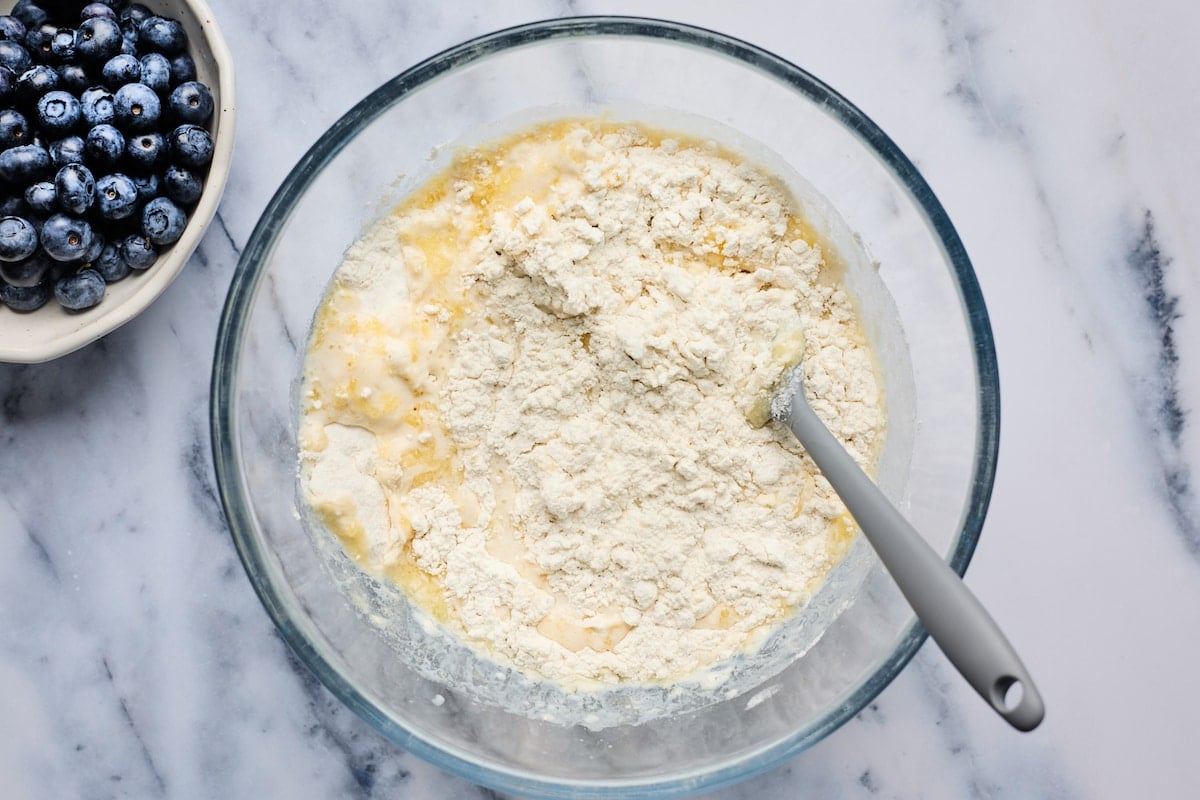 biscuit dough being stirred together in mixing bowl with spatula. 