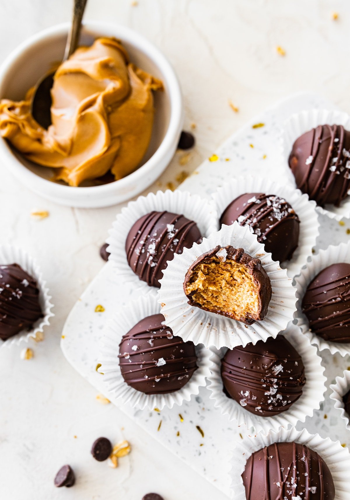 chocolate dipped peanut butter protein balls in mini paper cups. 