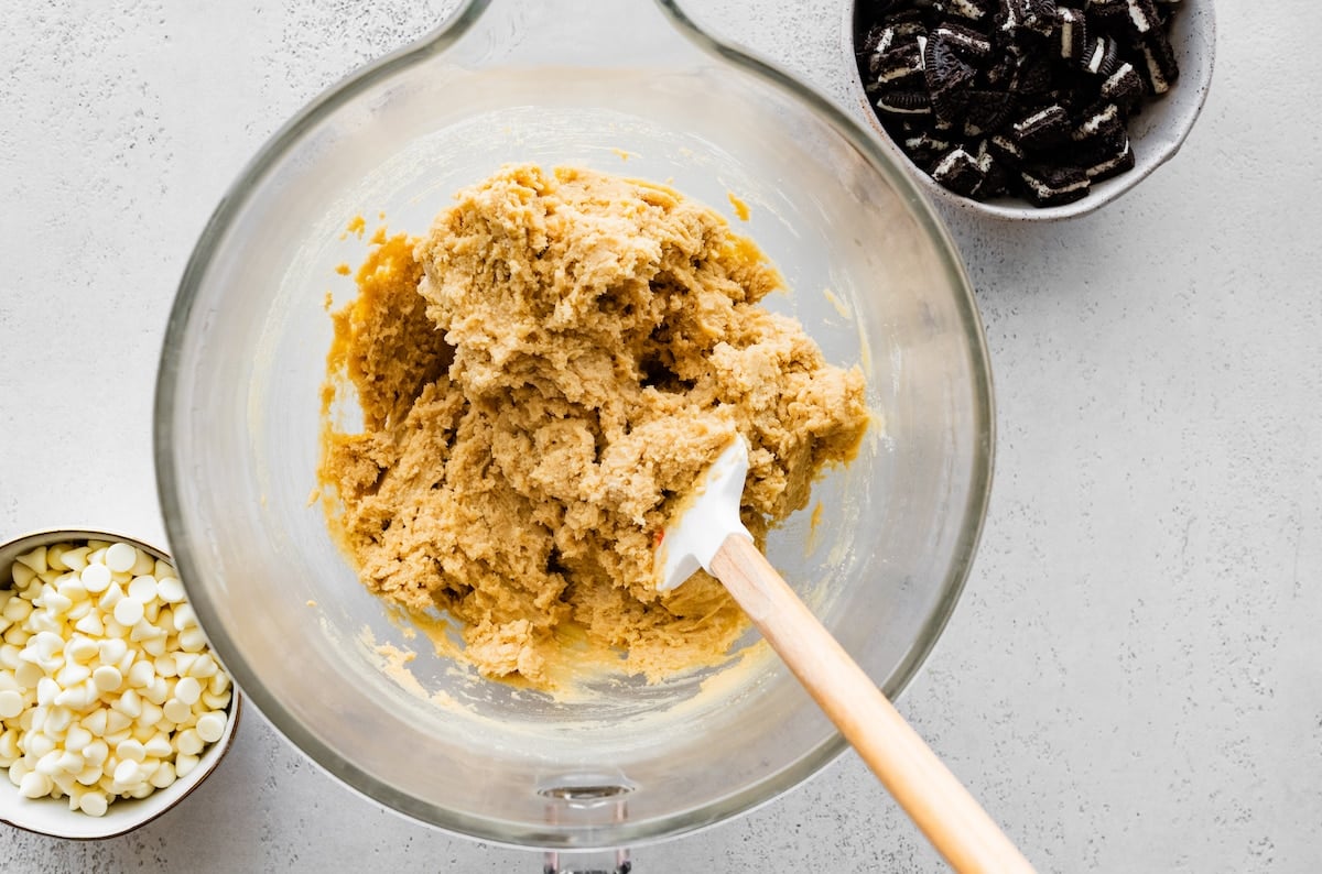 cookie dough in mixing bowl with spatula. 