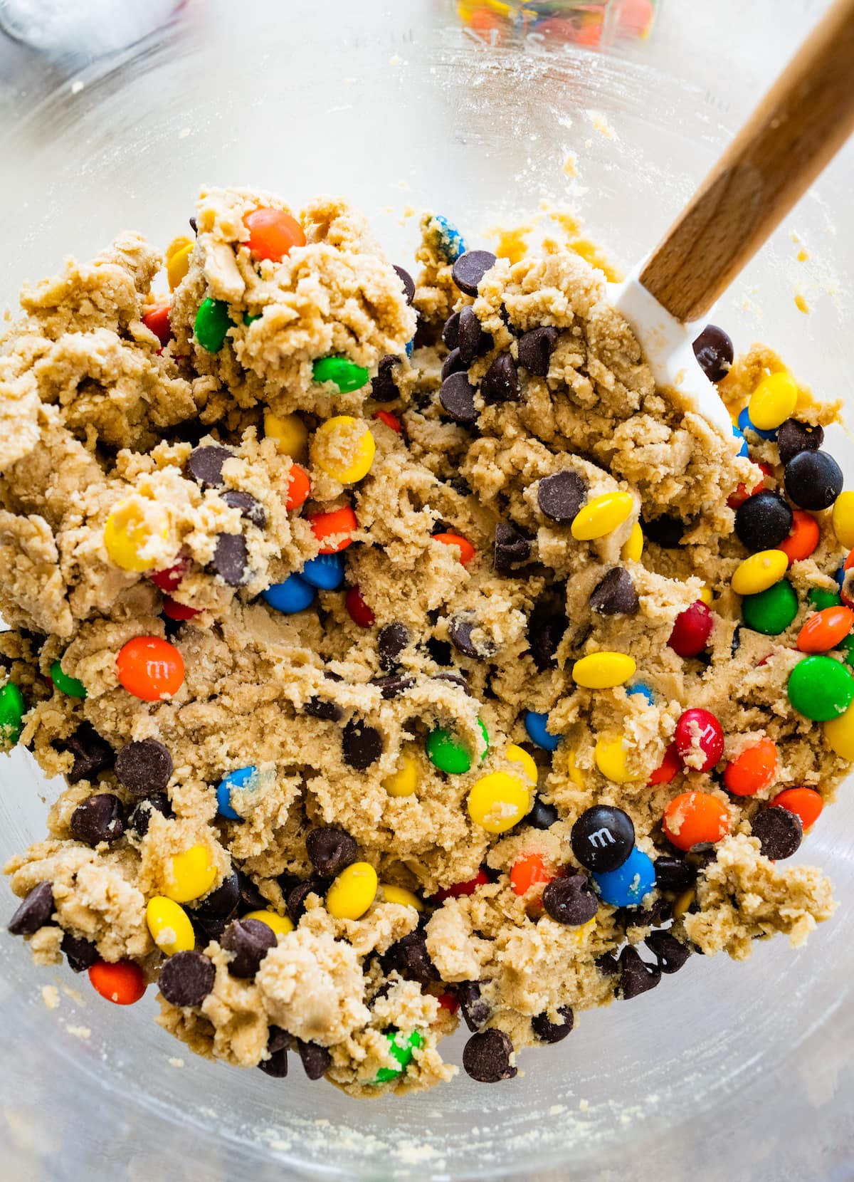 M&M cookie bar dough in mixing bowl with spatula. 