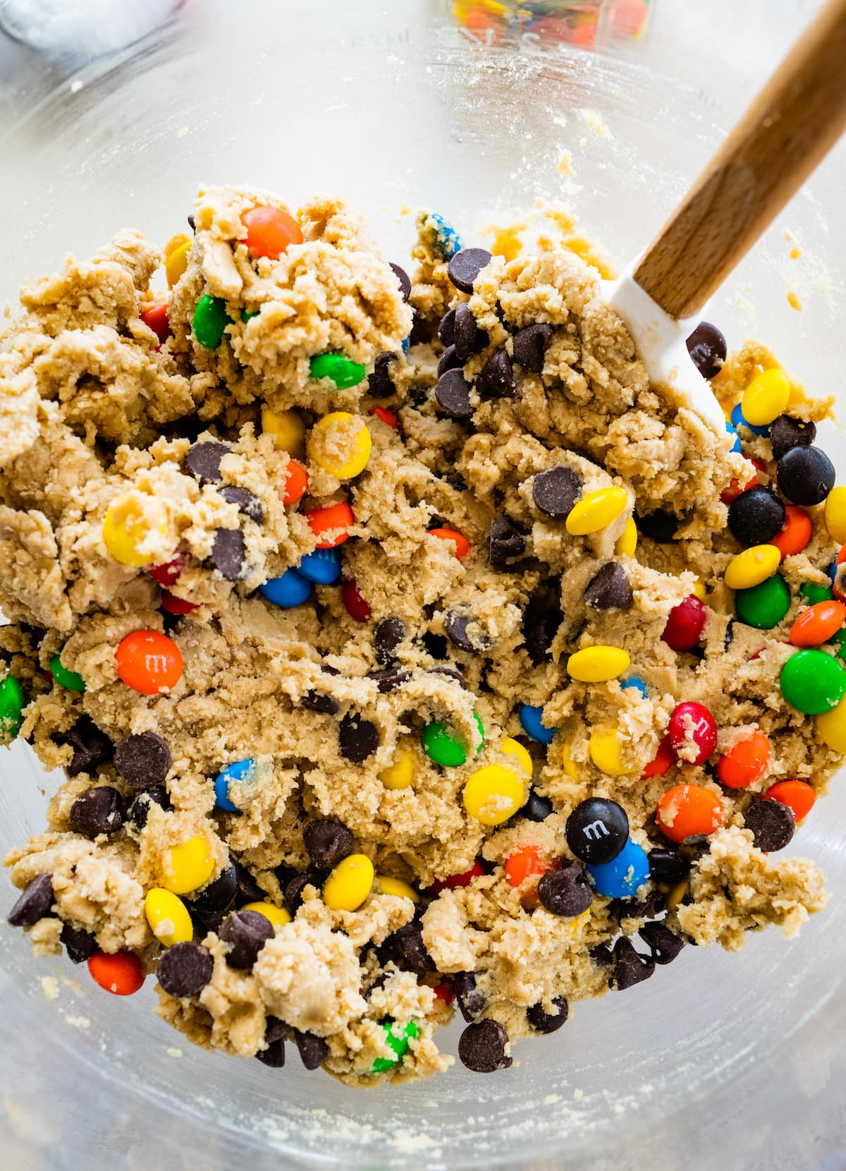 M&M cookie bar dough in mixing bowl with spatula.