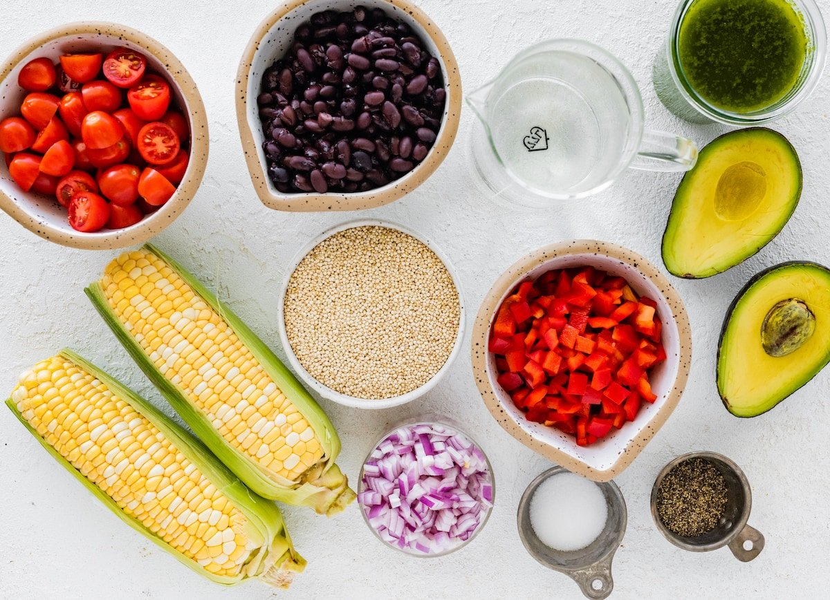 tomatoes, black beans, corn, quinoa, onion, red pepper, avocado, and cilantro lime dressing to make southwest quinoa salad.