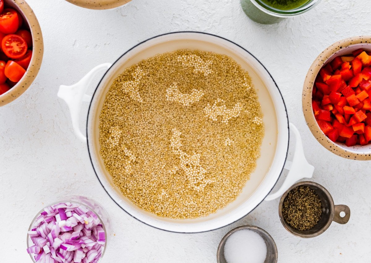 uncooked quinoa and water in large white pot. 