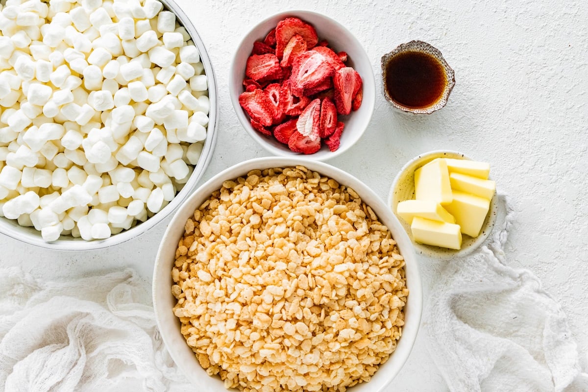 marshmallows, freeze dried strawberries, vanilla, butter, and crispy rice cereal in bowls to make strawberry rice krispie treats. 