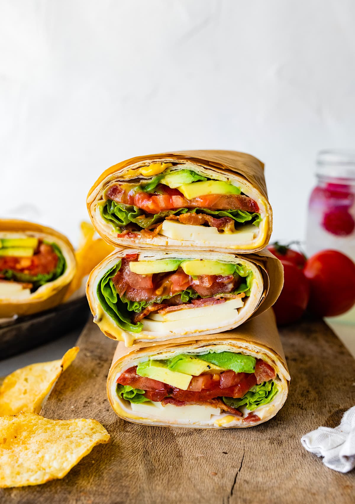 turkey wraps cut in half and staked on top of each other on wood cutting board. 