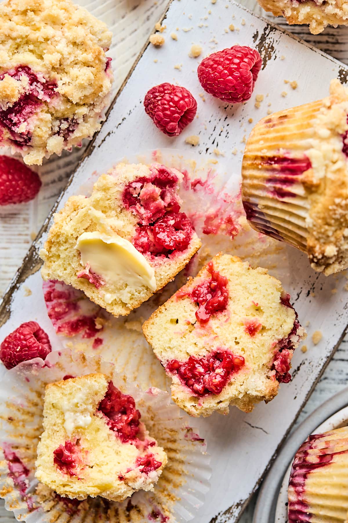 raspberry muffin cut in half with fresh raspberries and butter. 