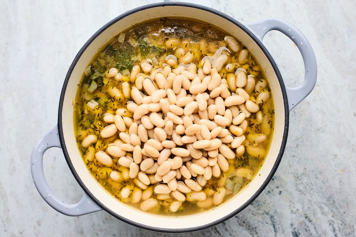zucchini soup with white beans in large pot. 