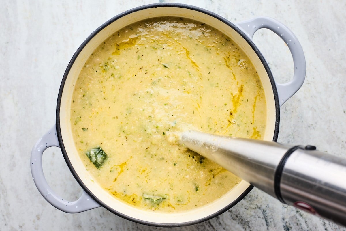 zucchini soup being blended with immersion blender. 