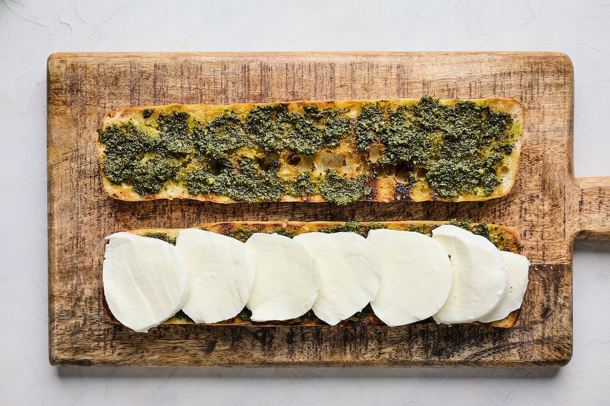 ciabatta bread topped with pesto and fresh mozzarella slices. 