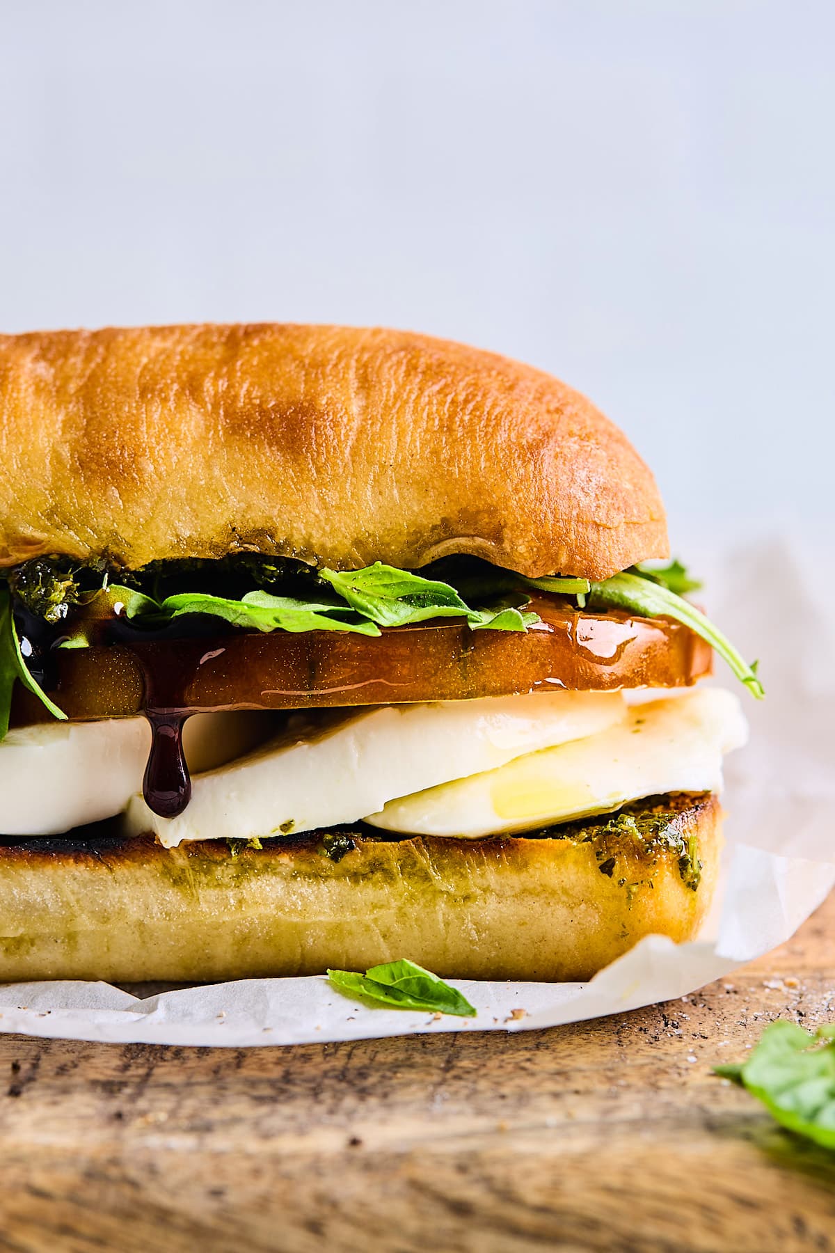 close up of caprese sandwich with blasamic glaze dripping. 