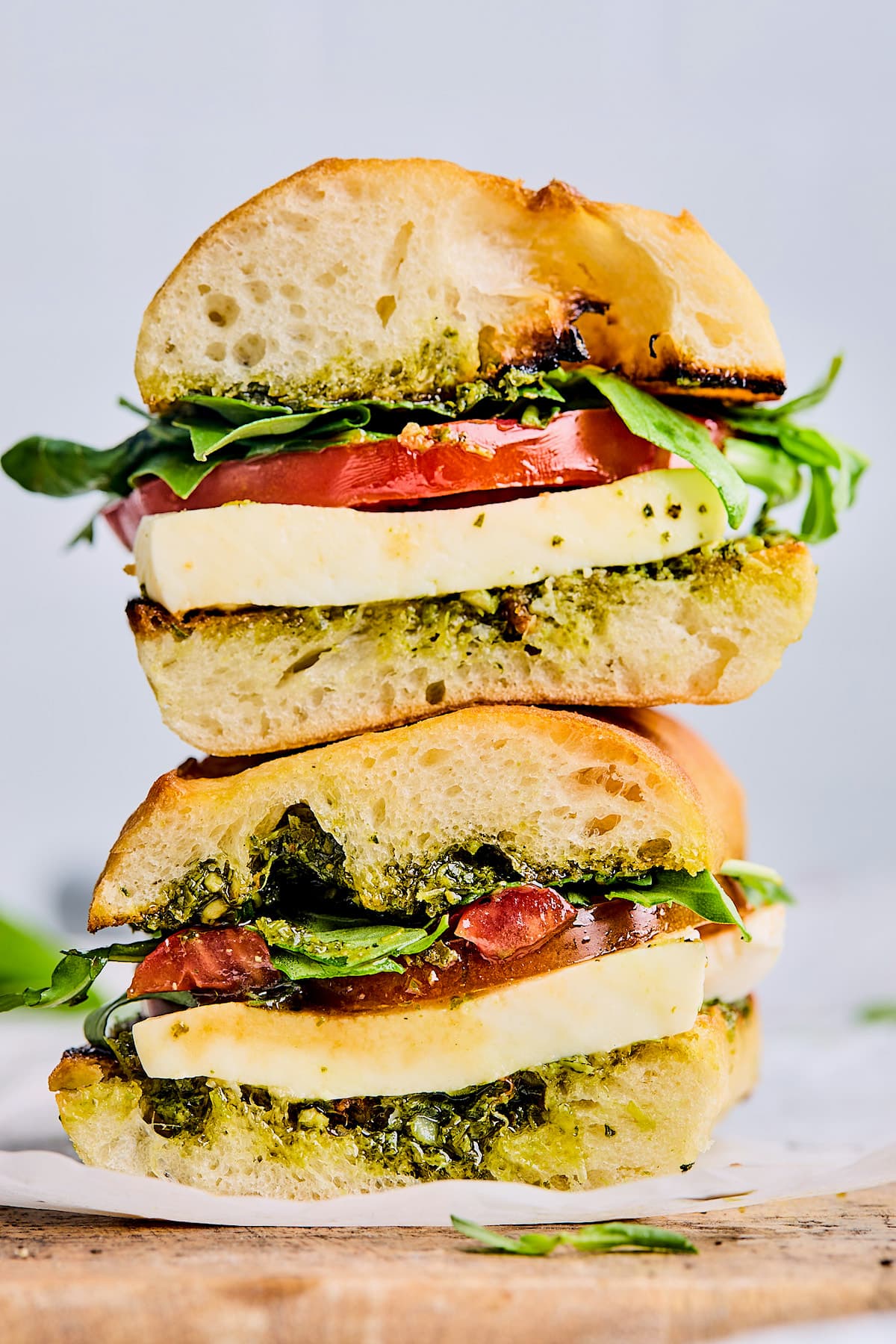 caprese sandwich cut in half stacked on top of each other. 