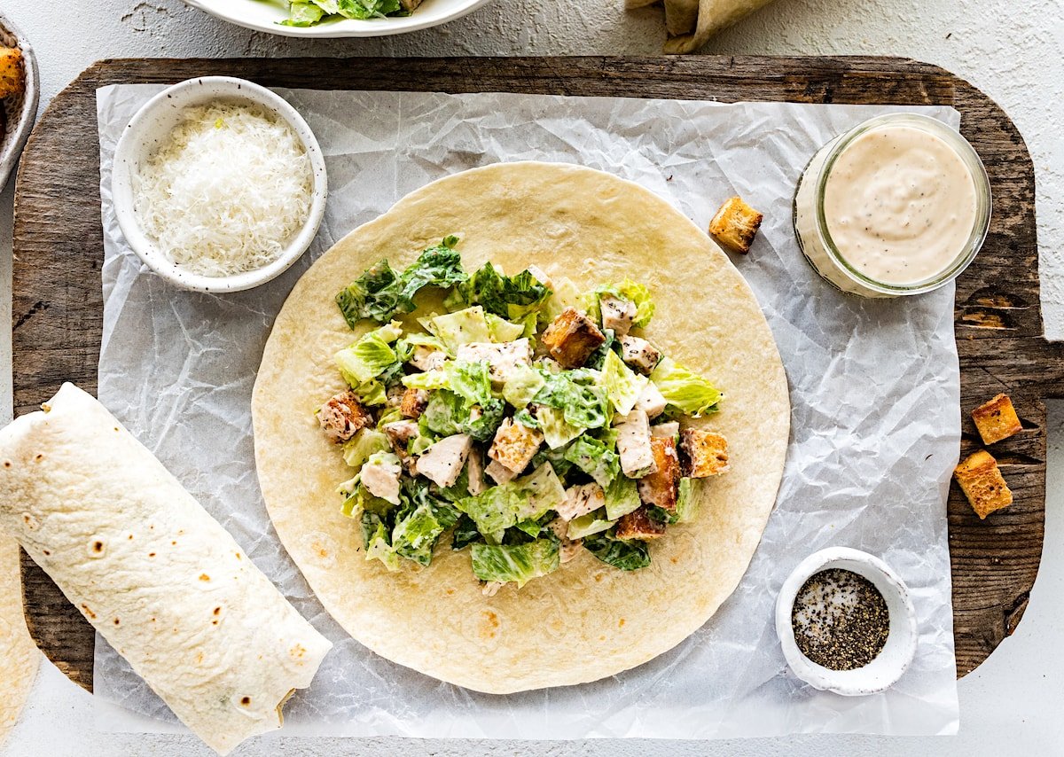 chicken caesar salad in the middle of a tortilla to make a wrap. 