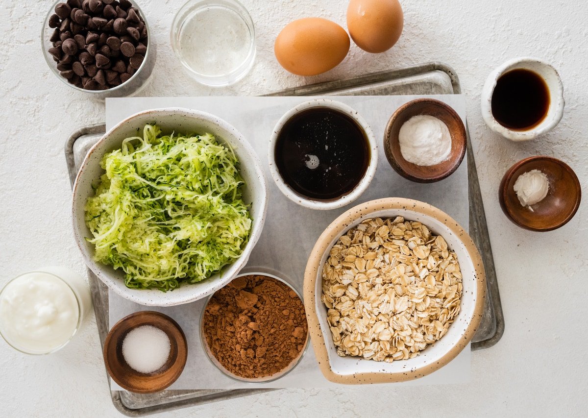 ingredients in bowls to make chocolate zucchini snack cake. 