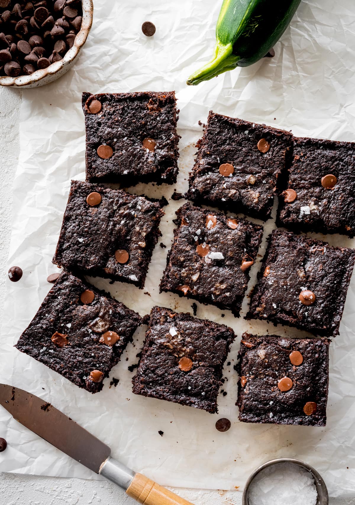 chocolate zucchini snack cake cut into squares on parchment paper. 