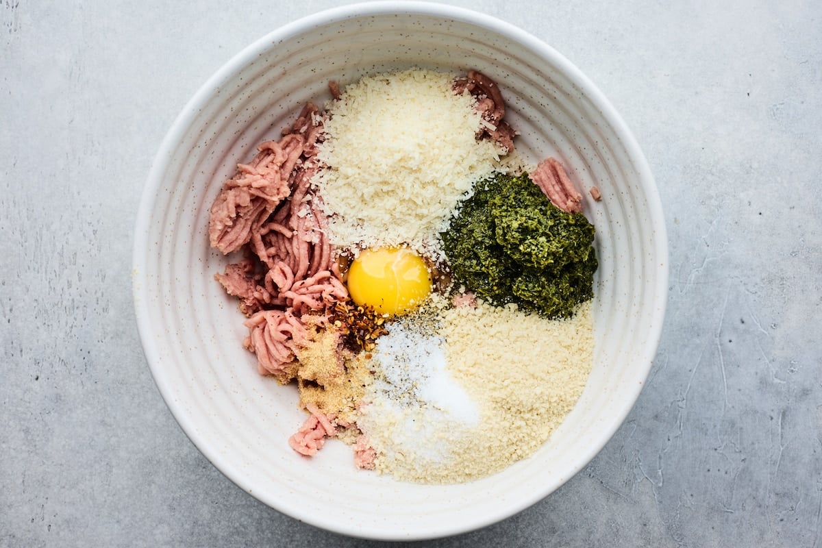 ground turkey, panko, Parmesan cheese, pesto, egg, garlic powder, and crushed red pepper flakes in mixing bowl to make pesto meatballs. 