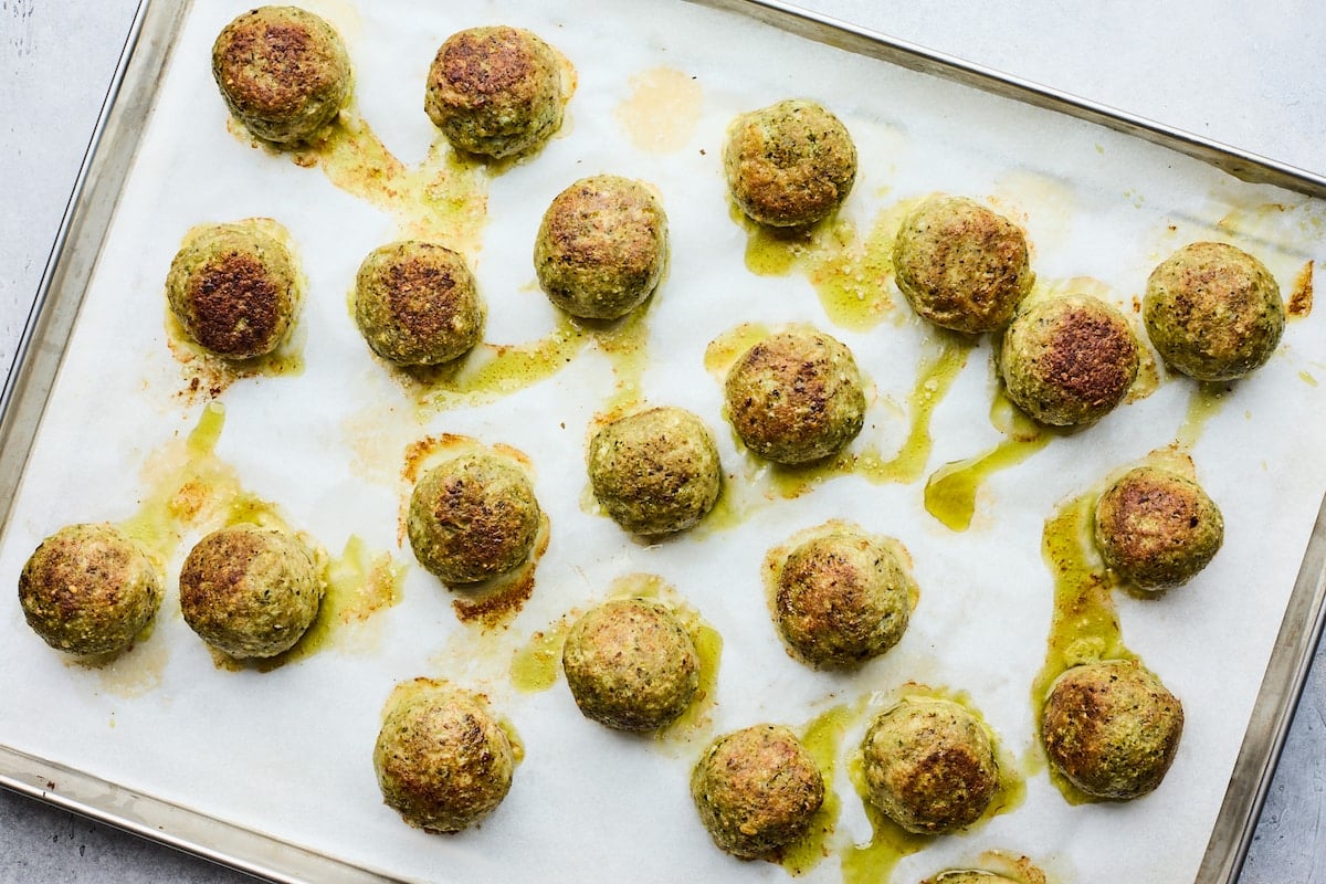 pesto meatballs on large baking sheet lined with parchment paper. 