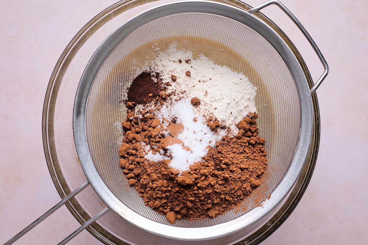 dry ingredients being sifted into mixing bowl to make raspberry brownies. 