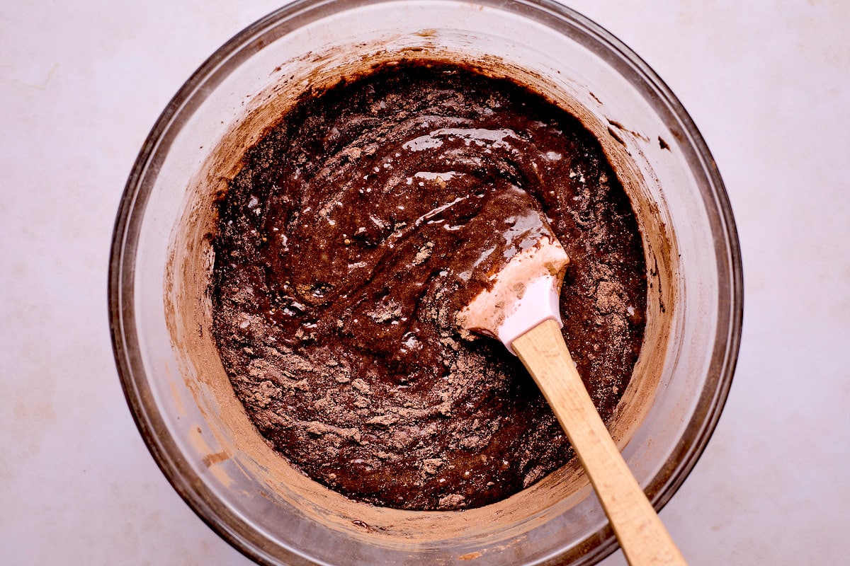 brownie batter in mixing bowl with spatula. 