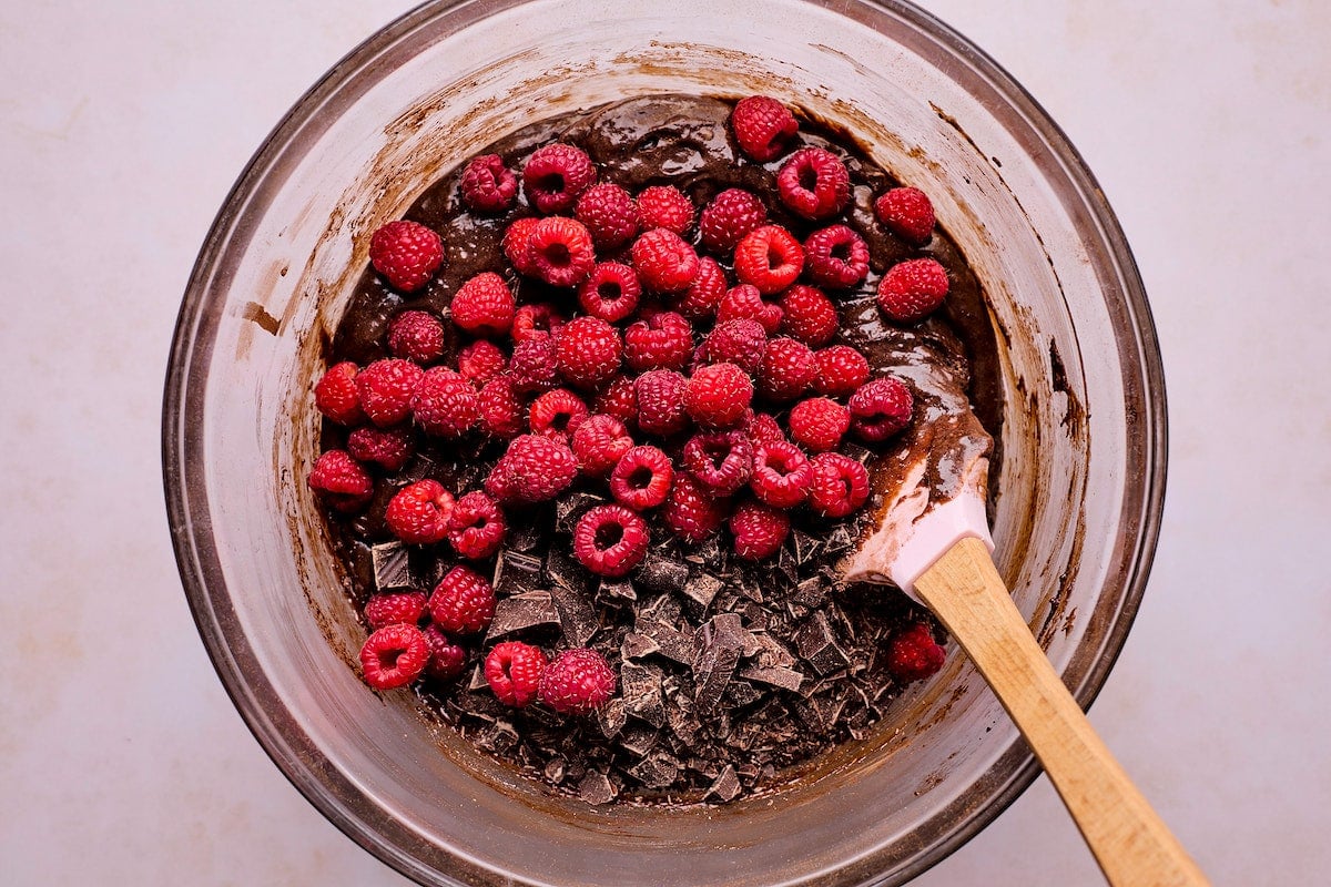 raspberry brownie batter in mixing bowl with spatula. 