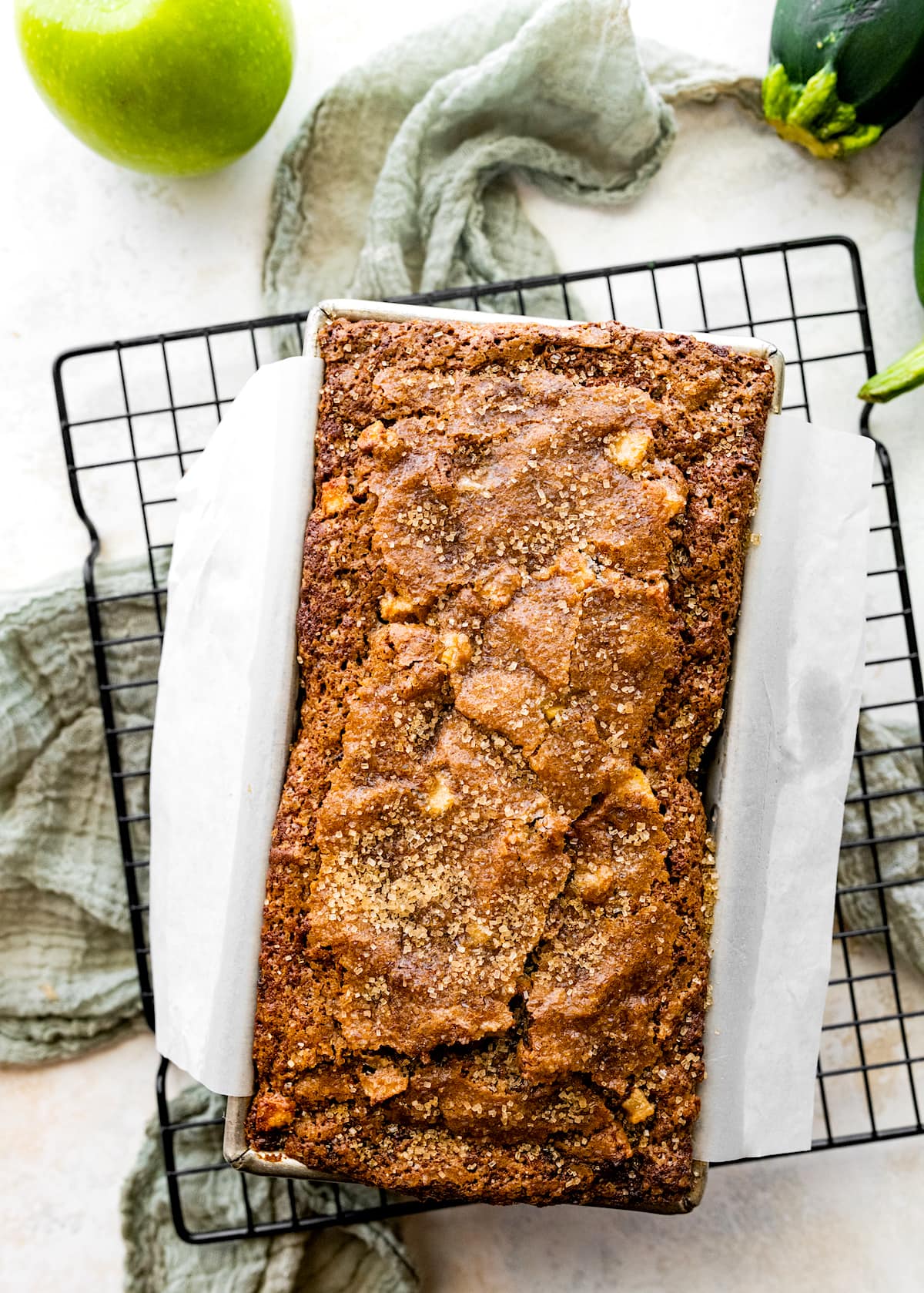 apple zucchini bread cooling in pan on wire cooling rack. 