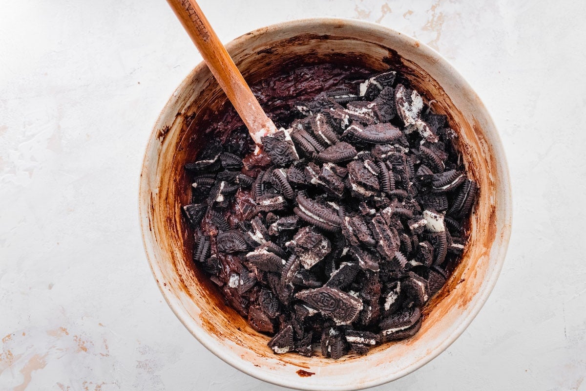 Oreo brownie batter in mixing bowl with spatula. 