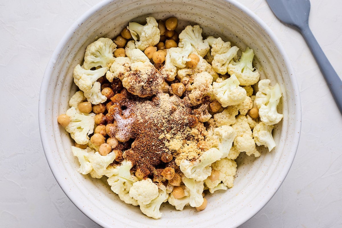 cauliflower, chickpeas, and spices in mixing bowl. 
