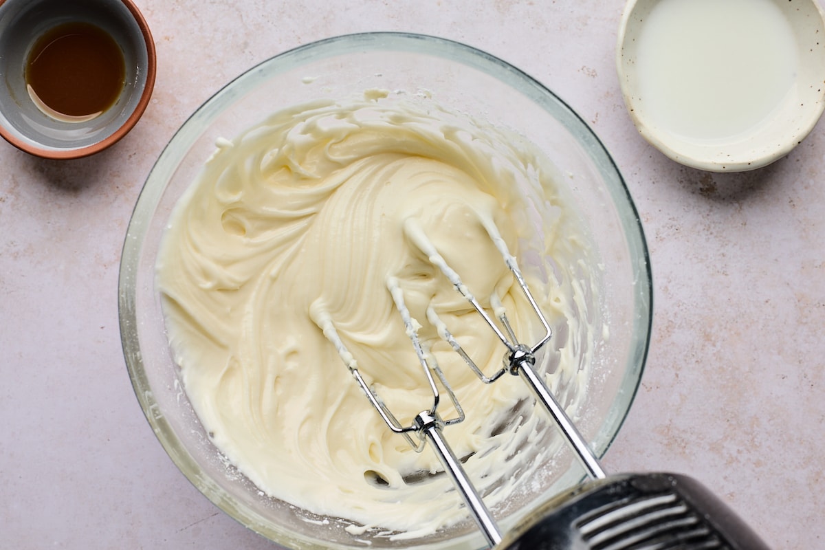 cream cheese frosting in bowl with hand mixer. 