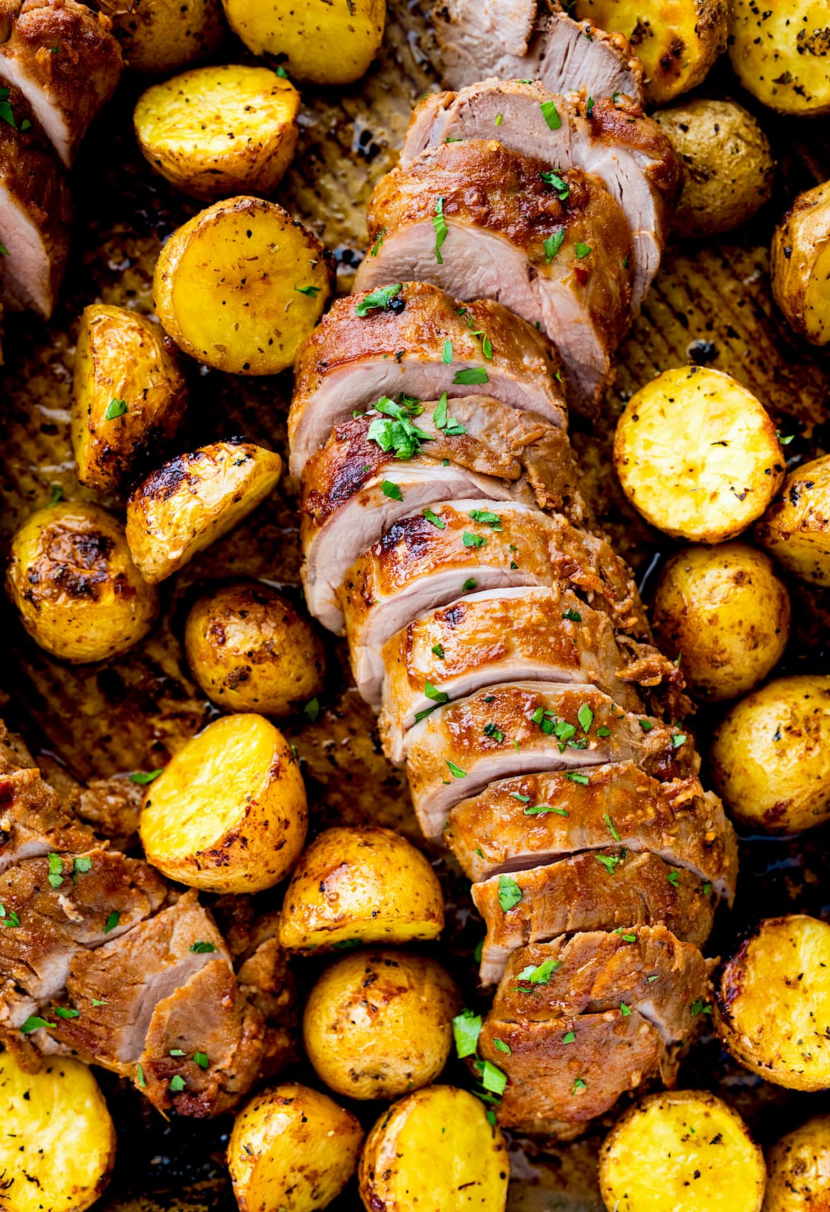 pork tenderloin on sheet pan with potatoes. 