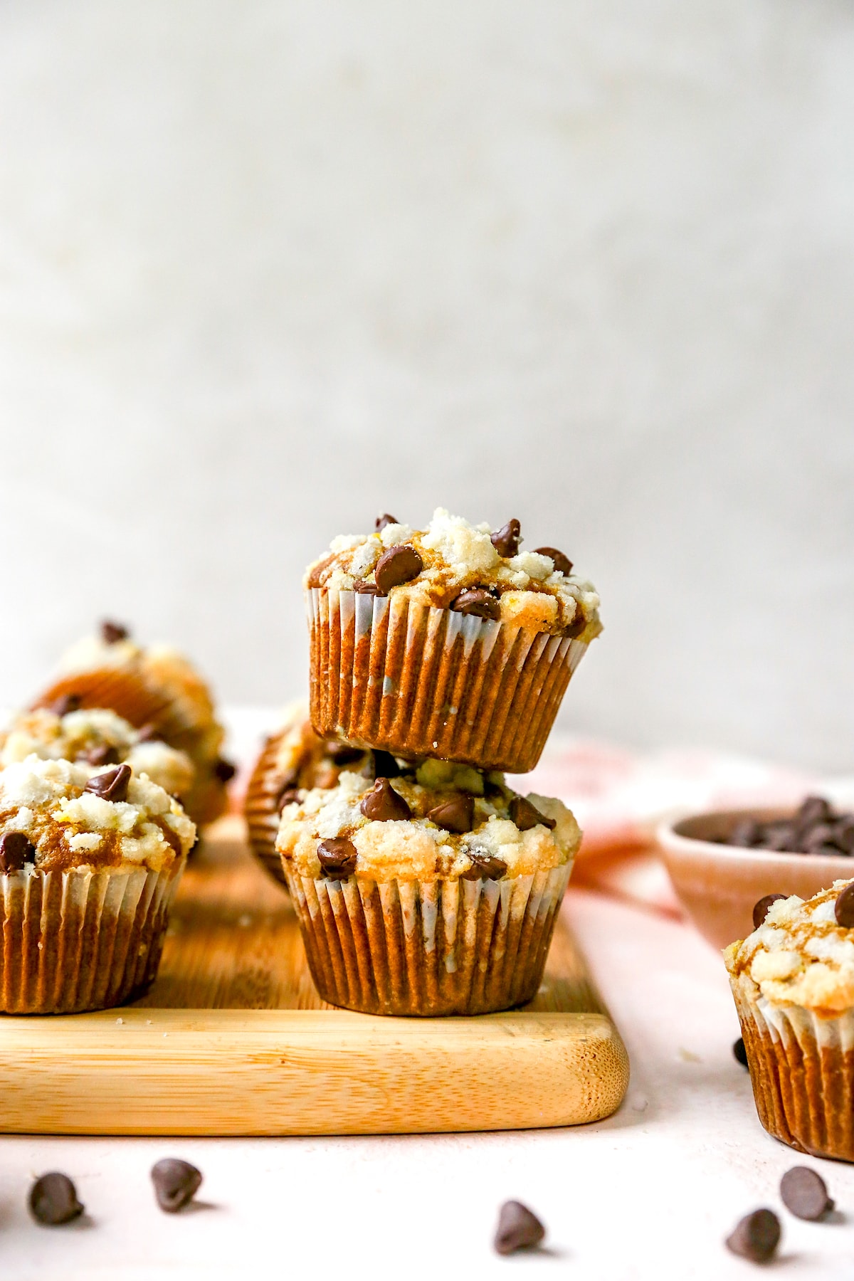 pumpkin chocolate chip muffins with streusel topping stacked on top of each other. 