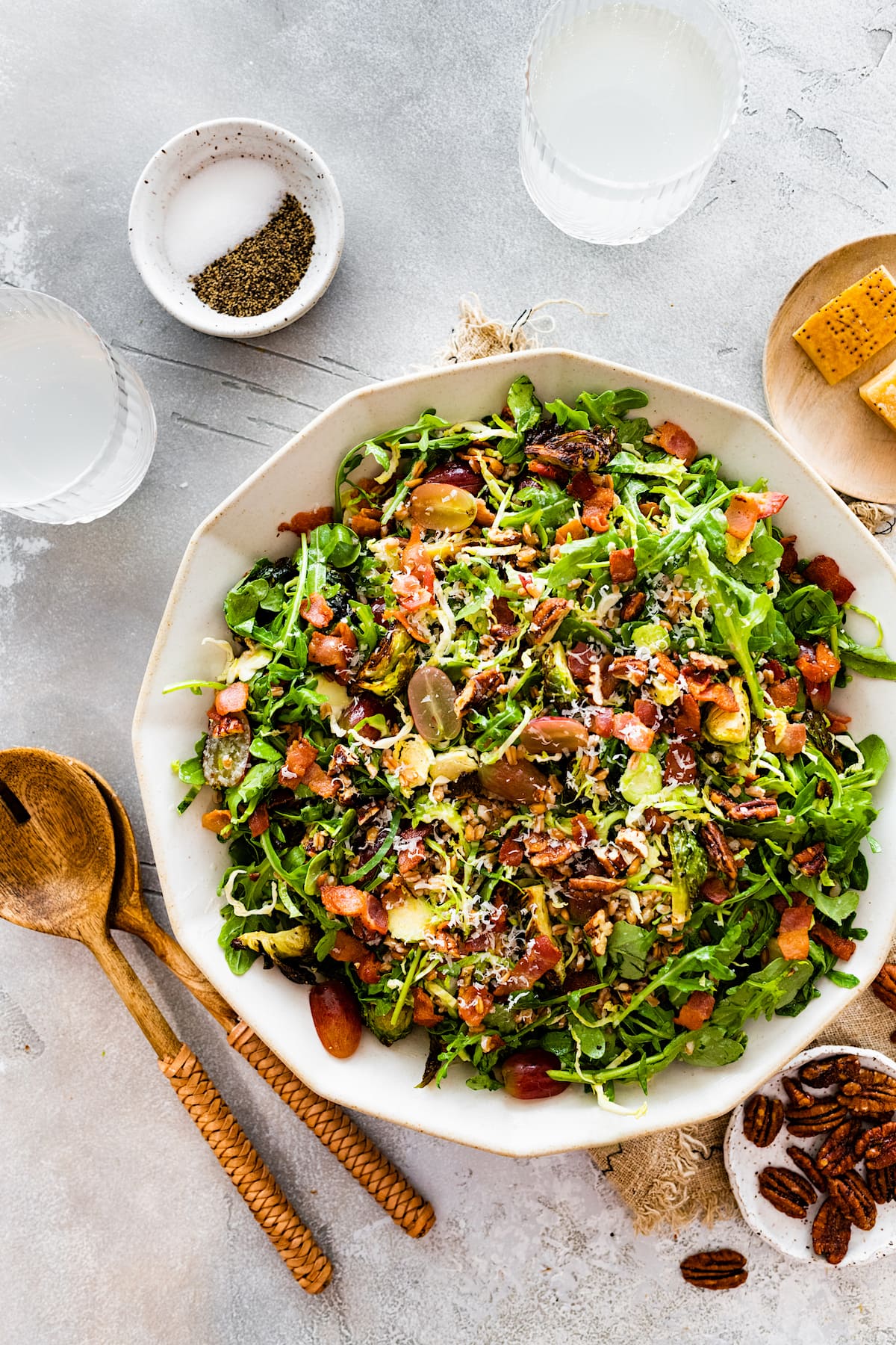 bacon brussels sprouts salad with grapes, pecans, and parmesan cheese in bowl. 