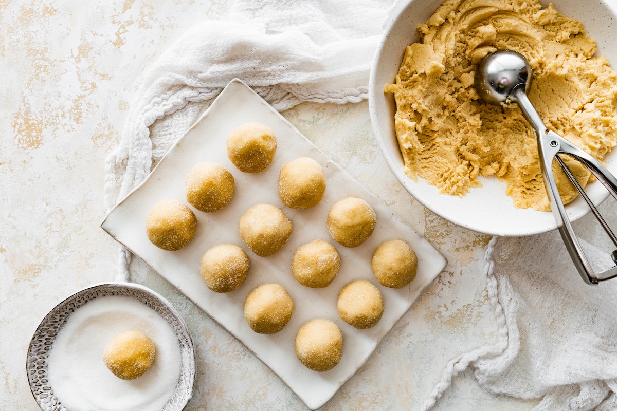 brown butter sugar cookies being scooped into balls. 