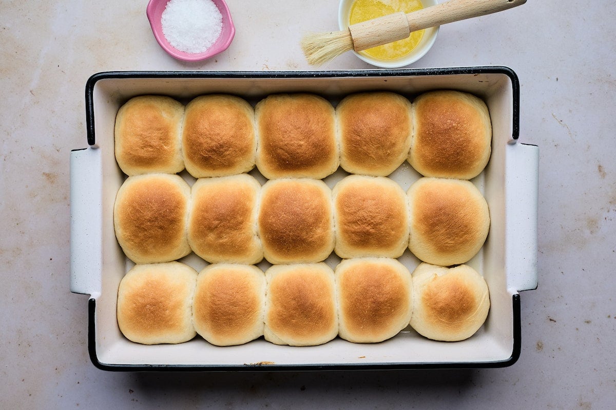 dinner rolls in baking pan getting ready to be brushed with melted butter. 
