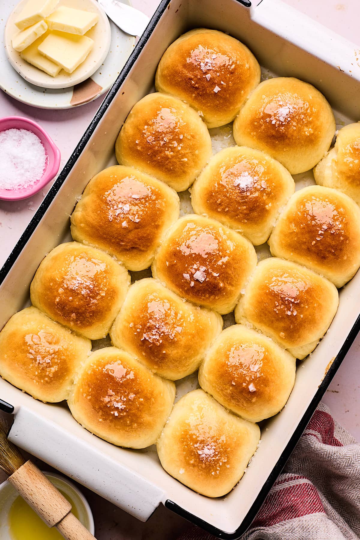 dinner rolls in baking pan brushed with butter and flaky sea salt. 