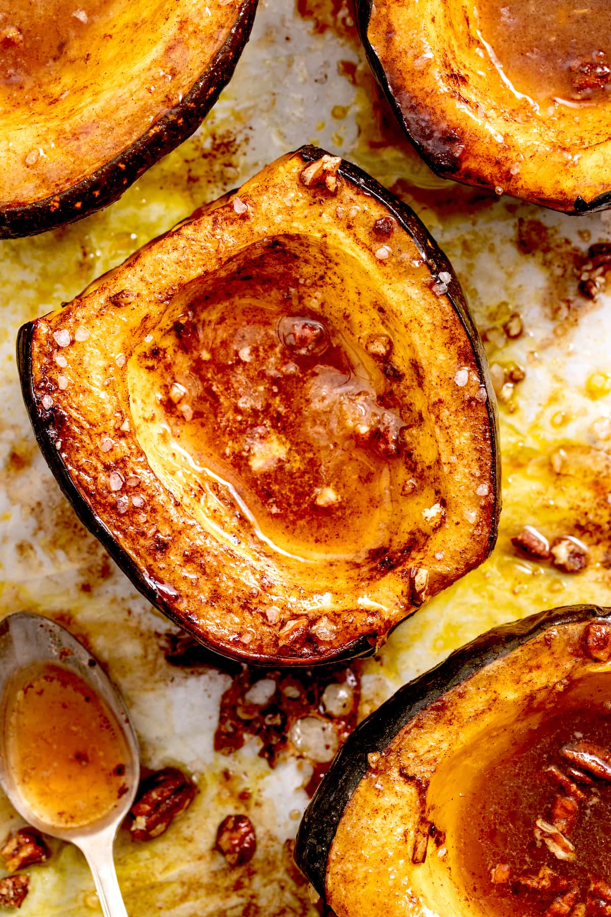 close up of roasted acorn squash with melted butter, maple syrup, and cinnamon. 