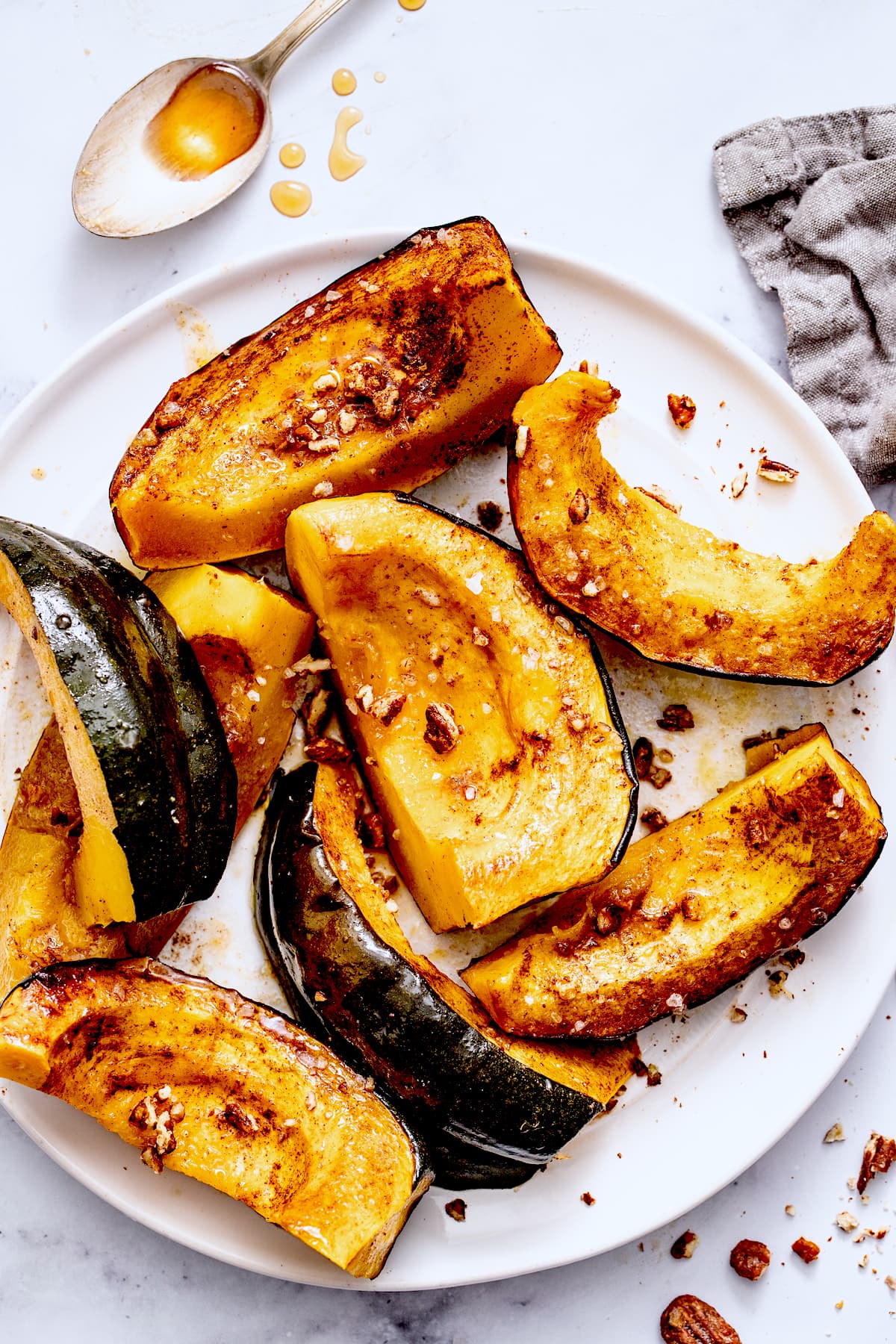 roasted acorn squash cut in wedges on white plate. 