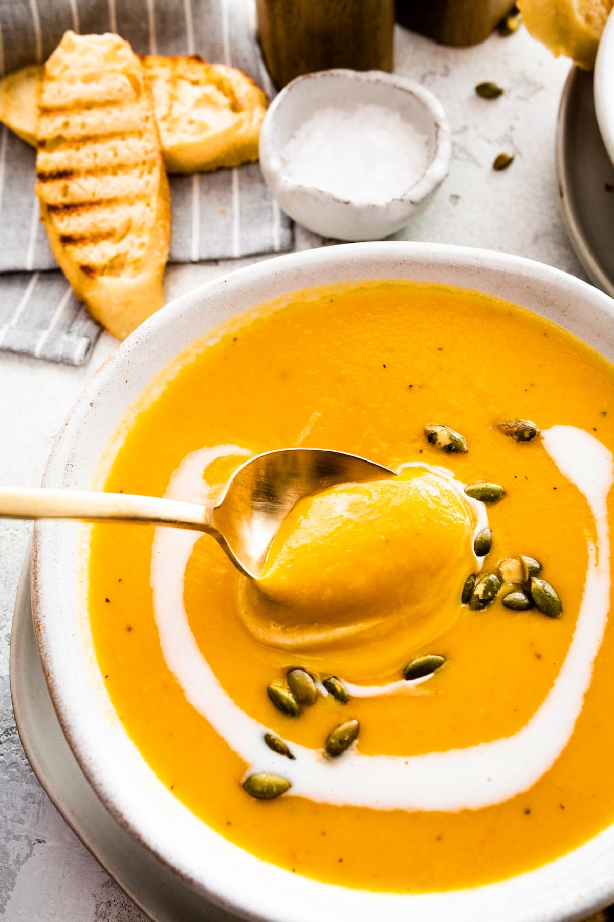 roasted butternut squash pear ginger soup in bowl with spoon. 