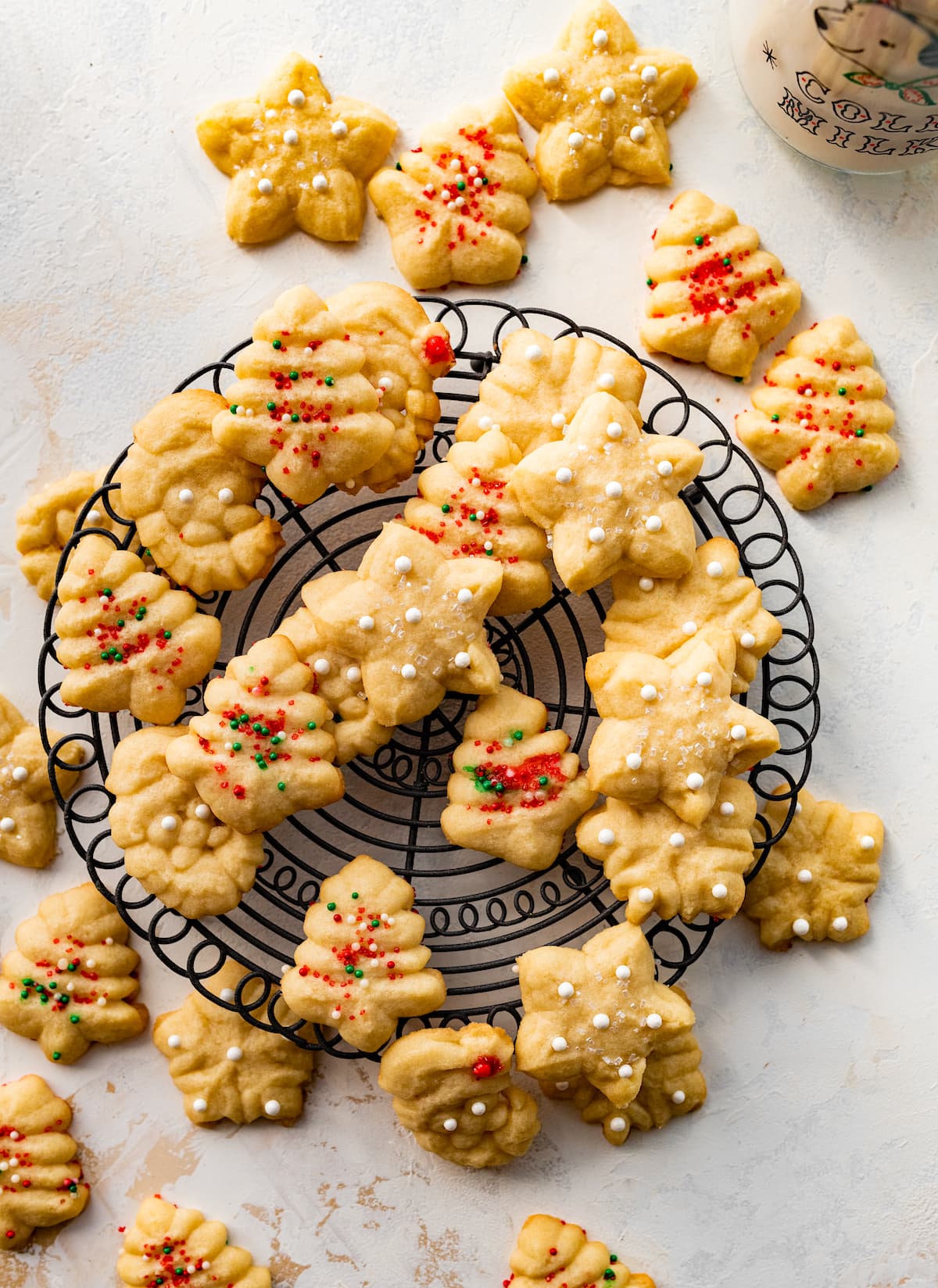 spritz cookies with sprinkles on cooling rack. 