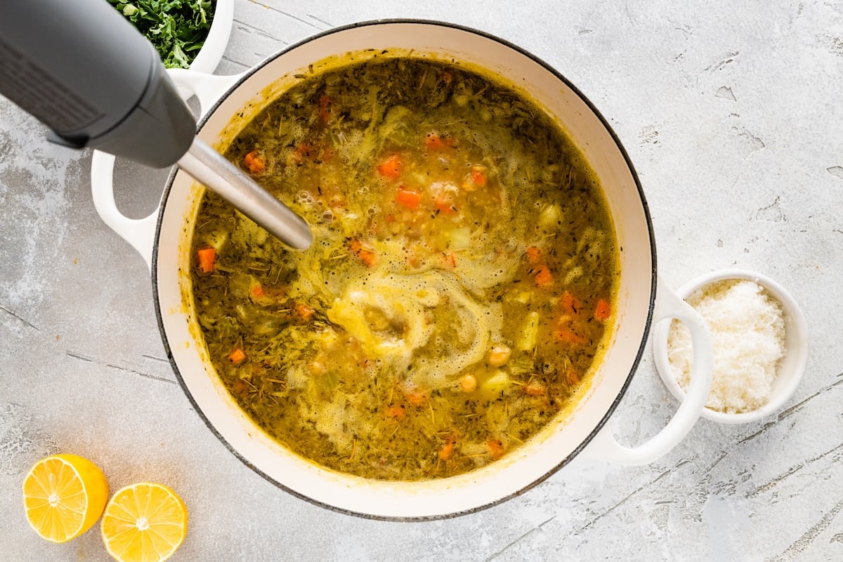 immersion blender in soup pot blending chickpea soup. 