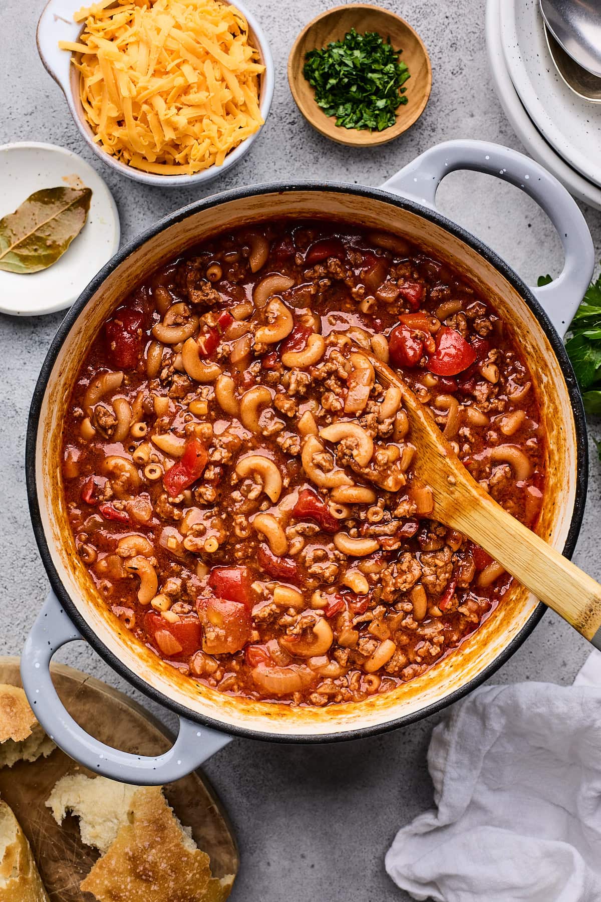American goulash in large pot with wooden spoon. 