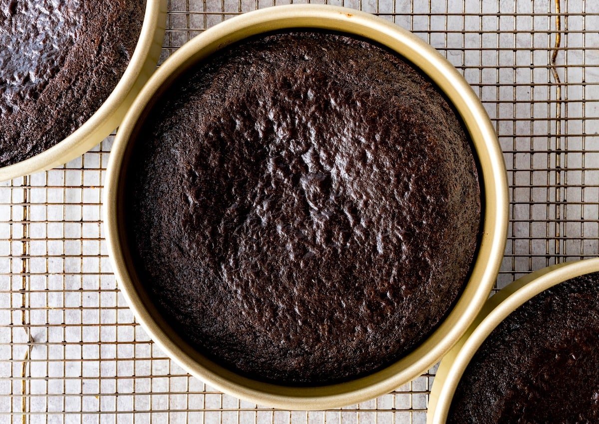 chocolate cake in cake pans on cooling rack. 