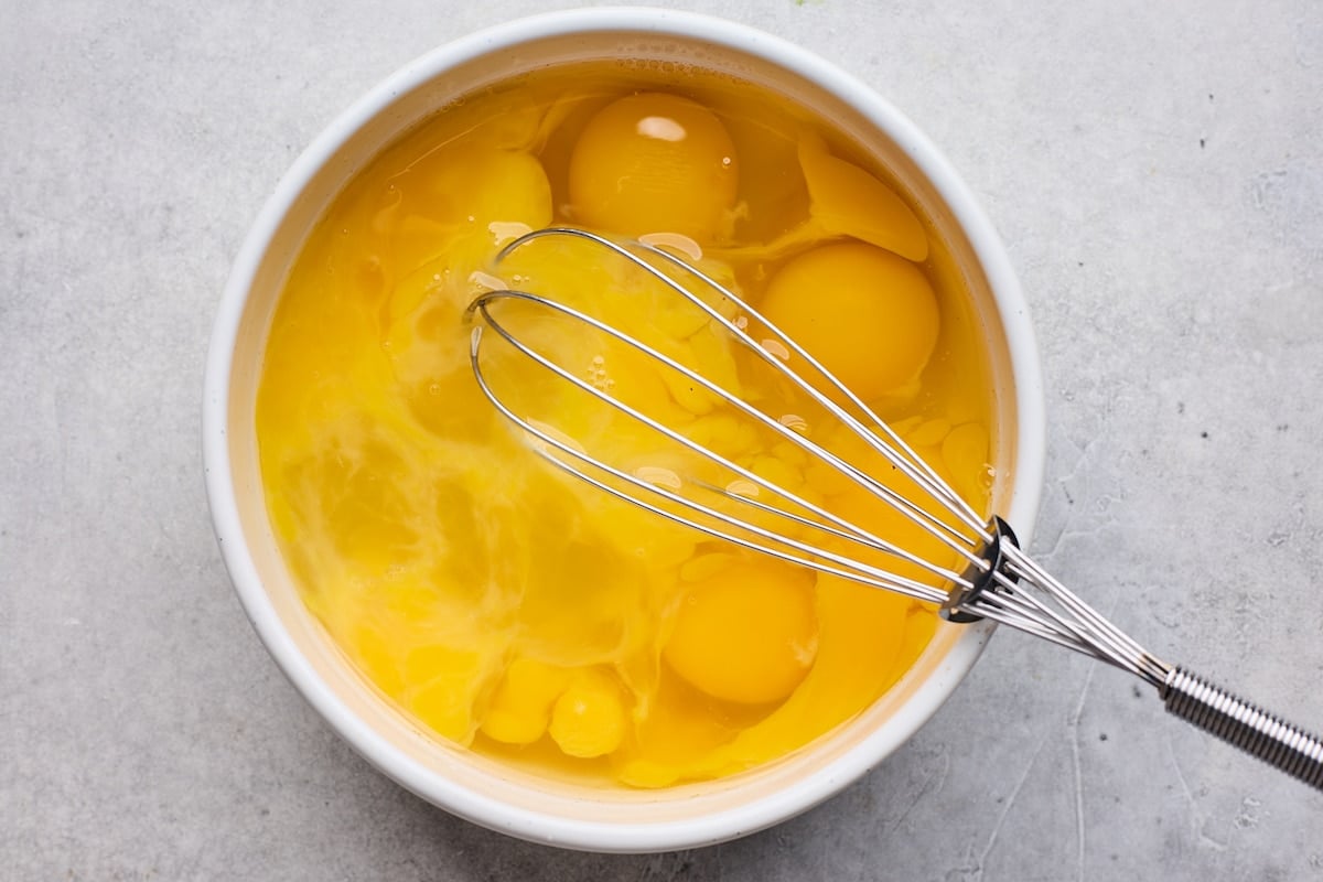eggs in bowl with whisk. 