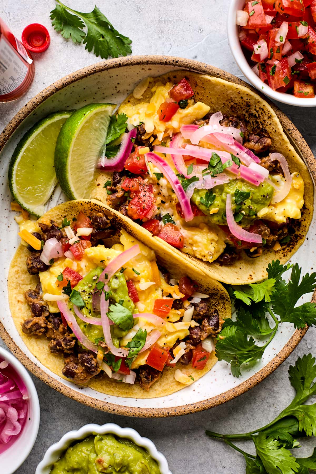 plate of breakfast tacos with toppings. 