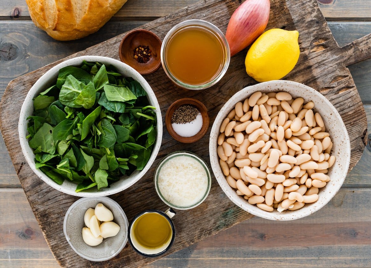 ingredients in bowls to make creamy white beans with spinach. 