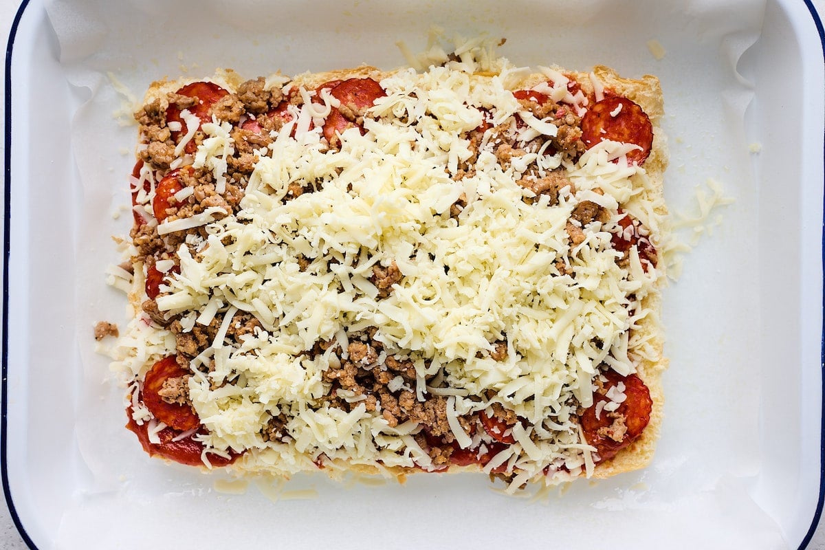 pepperoni, sausage, ad shredded mozzarella cheese on top of Hawaiian sweet rolls to make pizza sliders. 